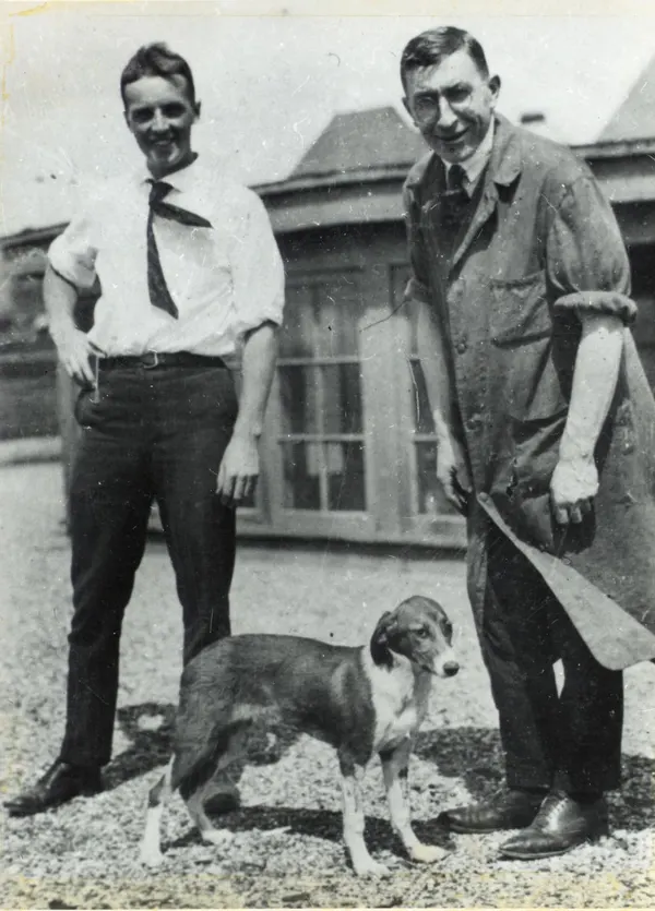 Charles Best and Frederick Banting standing with a dog on a University of Toronto rooftop in 1921